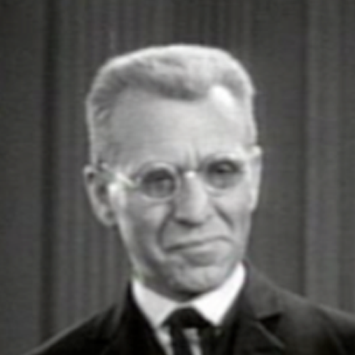 A black-and-white image of a lght-skinned man with circular glasses